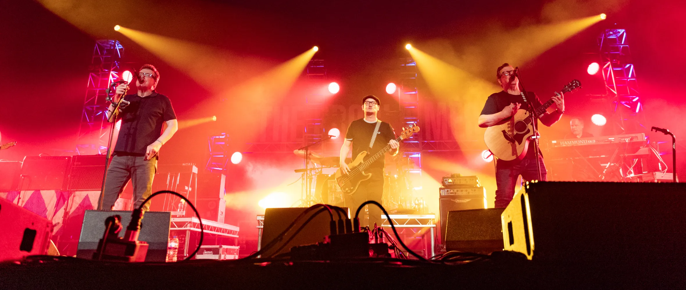 The Proclaimers performing on stage under red and yellow lights.