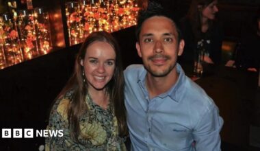Richard Pugh and Hannah Norman smiling at the camera, dressed to go out. Richard has short dark hair and a goatee, while Hannah has long straight hair.