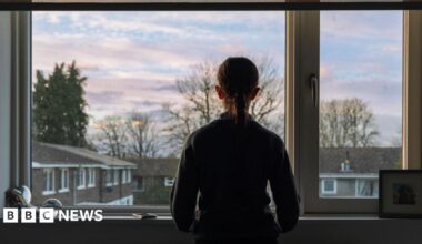 A teenager looking out a window