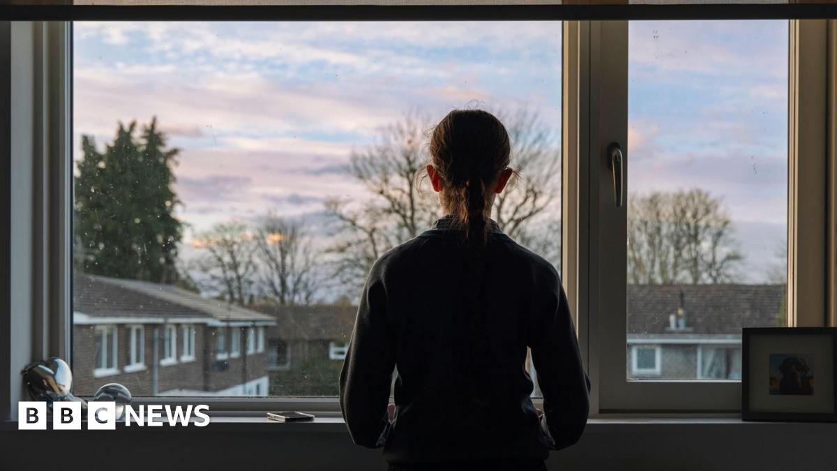 A teenager looking out a window