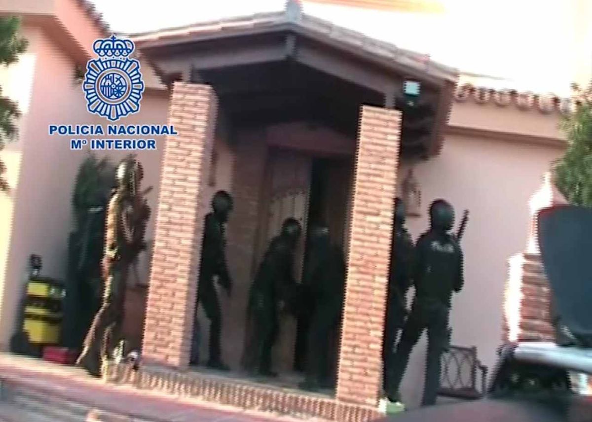 Police break down the front door of Mark Lilley's villa