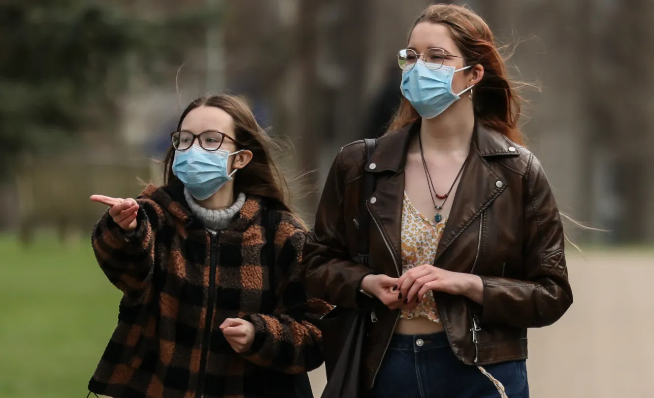 Two students wearing facemasks walking outdoors.
