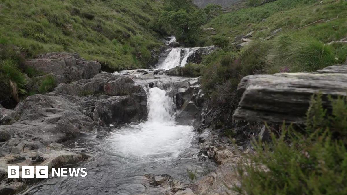A national park's beauty spot shows a waterfall and rocks surrounded by a pool.