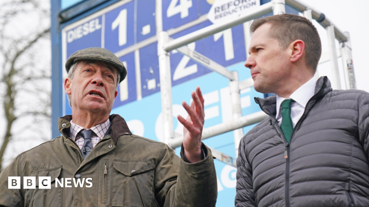 Nigel Farage and Robert Jenrick speaking at a news conference at a petrol station in Derbyshire