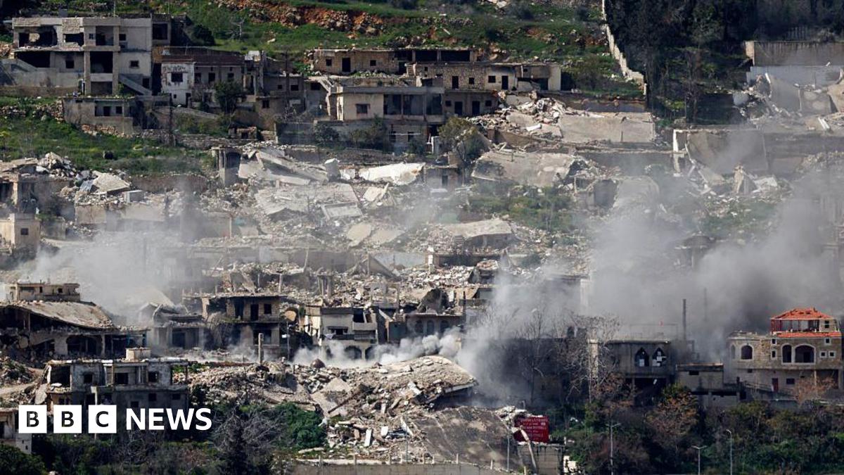 Smoke rises from bombed out buildings.
