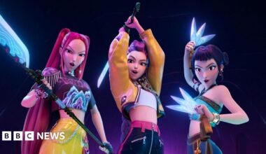 Children posing around large cut-outs of characters from K-pop Demon Hunters