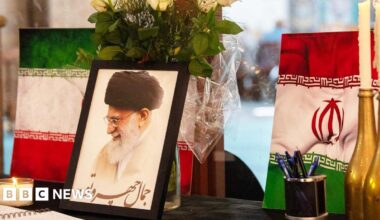 A portrait of Iran's Supreme Leader Ayatollah Ali Khamenei is displayed next to Iranian flags, candles and a book of condolences at a mosque in Cape Town