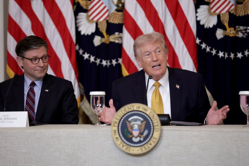 President Donald Trump sits with House Speaker Mike Johnson during a lunch with the Kennedy Center Board Members in the East Room of the White House on March 16, 2026.