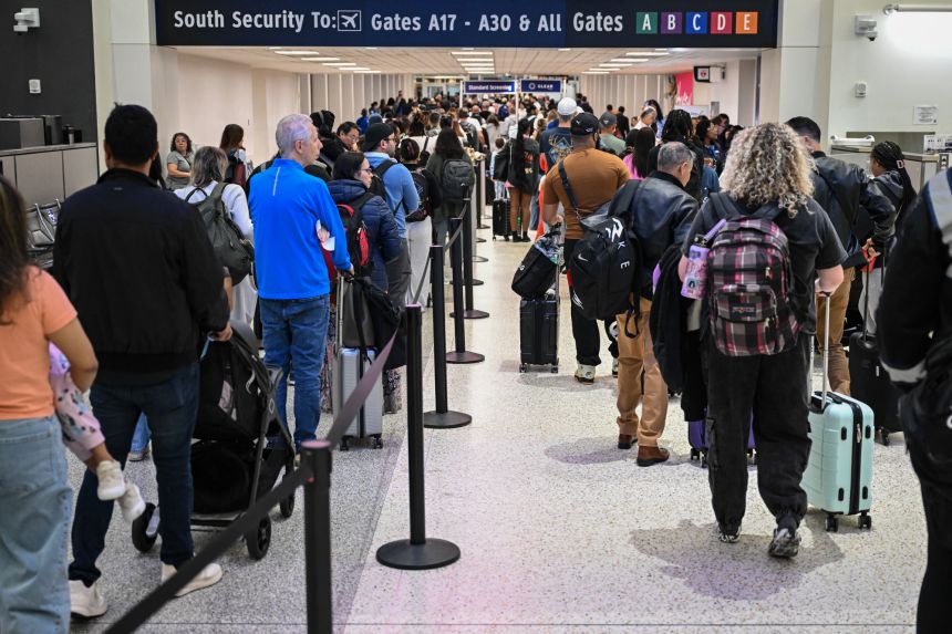 Travelers wait in line at a TSA security checkpoint at George Bush Intercontinental Airport in Houston, Texas on March 20.
