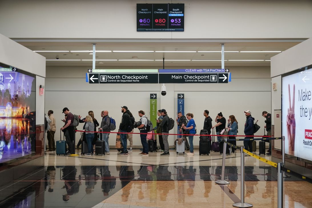 Travelers wait in line at a Transportation Security Administration checkpoint at Hartsfield-Jackson Atlanta International Airport in Georgia, on Friday.