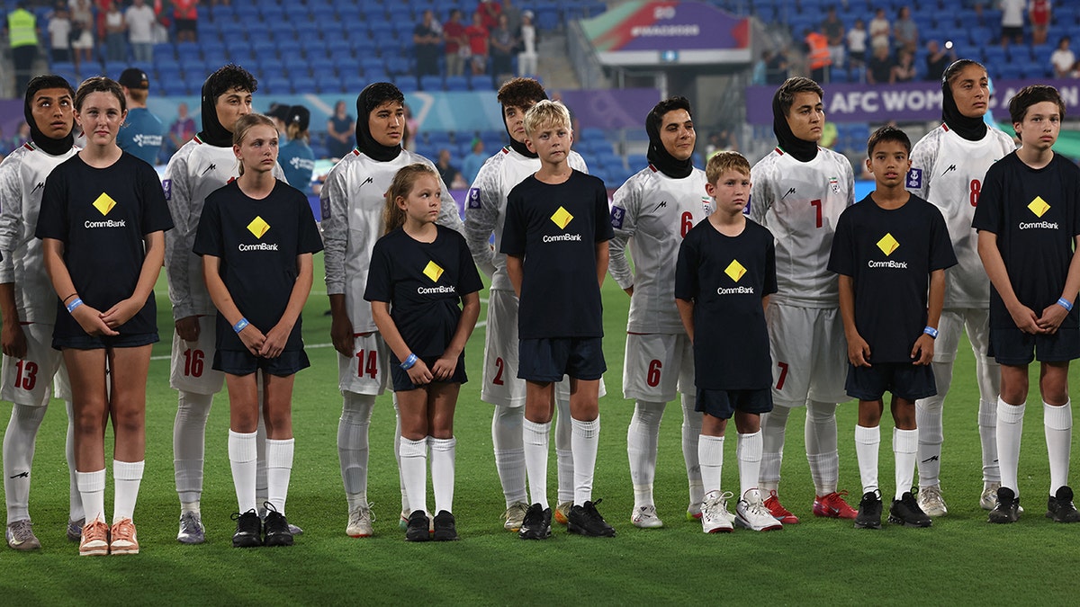 Team Iran standing and listening to national anthems before a football match.