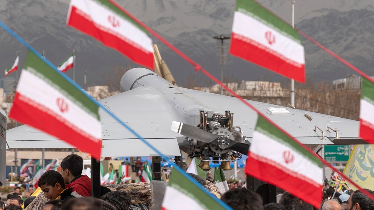 A military-style Iranian drone is showcased upright on a stand at a public square in Tehran.