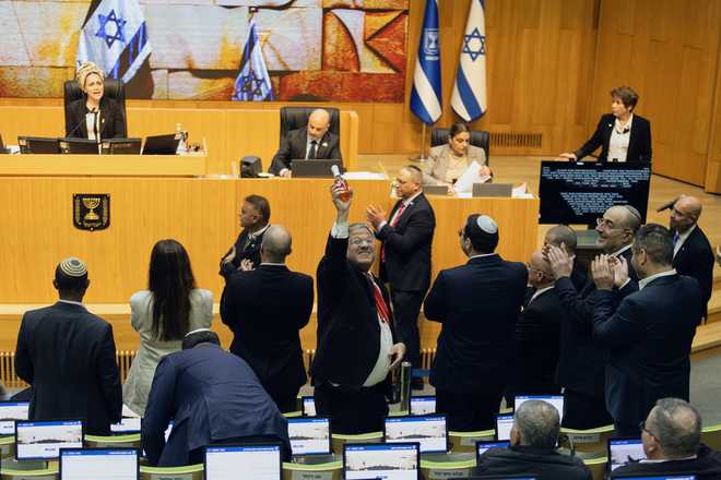 Israel's Minister of National Security, Itamar Ben-Gvir, center, and lawmakers celebrate after Israel's parliament passed a law approving the death penalty for Palestinians convicted of murdering Israelis, at the Knesset in Jerusalem.