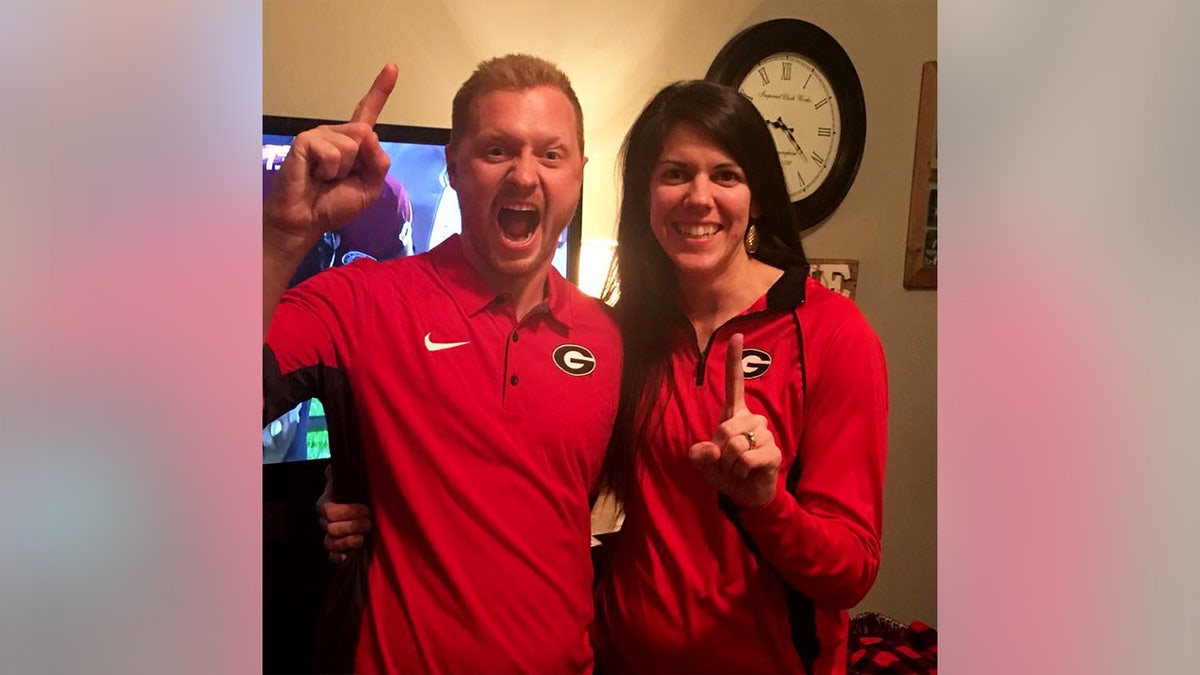 Jason and Laura Hughes smiling in an undated photo wearing University of Georgia football gear.