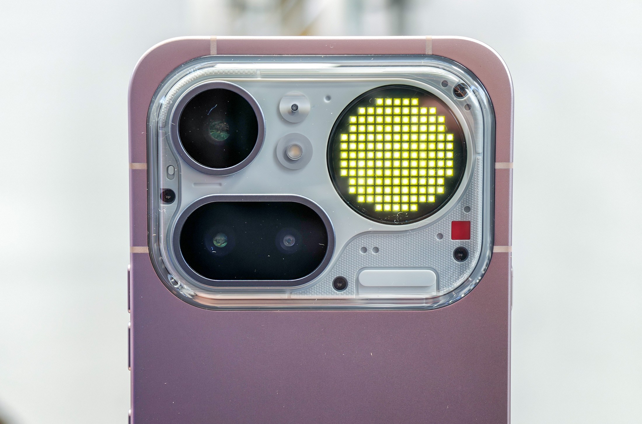 Photo of Nothing Phone 4A Pro in pink showing Glyph Matrix at London launch event