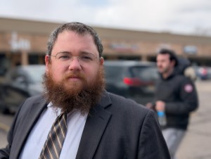 Rabbi Benny Greenwald stands in a parking lot. 