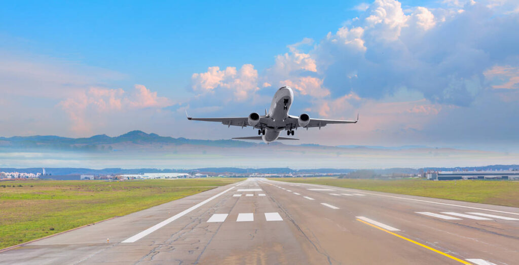a white plane taking off from a runway