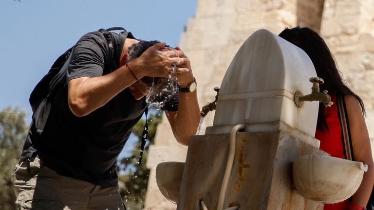 A man cools off with water in Athens, Greece, amid a heatwave in July 2025. Pic: AP
