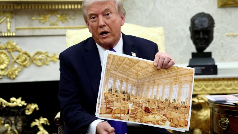 Donald Trump holds an image of the ballroom plans. Pic: Reuters