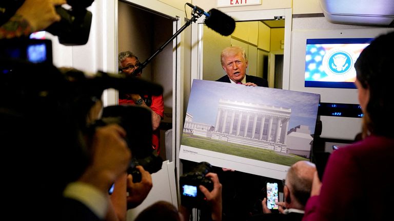 Mr Trump holds a renderings of the planned White House ballroom. Pic: Reuters