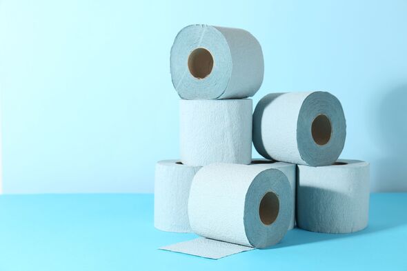 Stack of light blue toilet paper rolls on color background, space for text