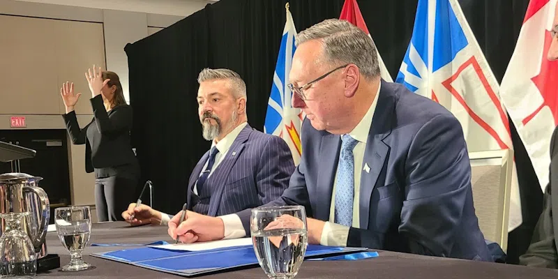 Premier Tony Wakeham signs the agreement.