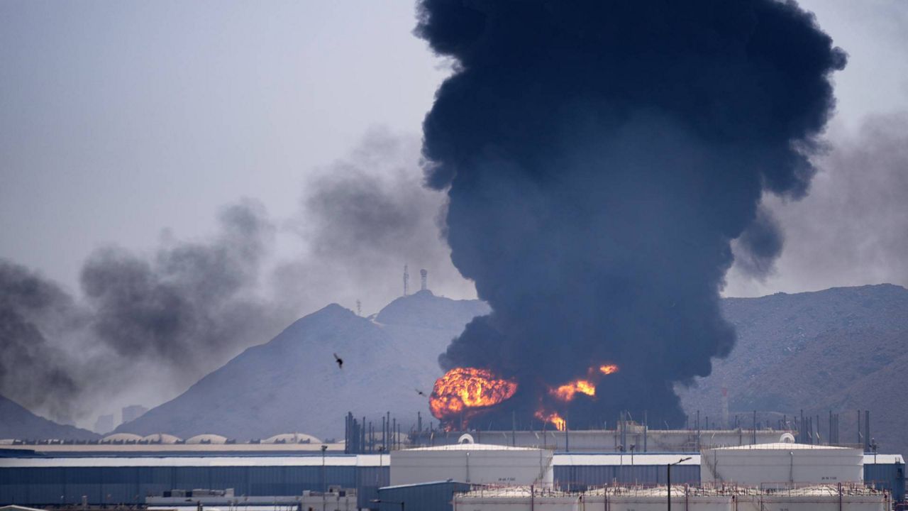 A fire and plume of smoke rise after, according to authorities. debris from an intercepted Iranian drone struck an oil facility in Fujairah, United Arab Emirates, Saturday, March 14, 2026.(AP Photo/Altaf Qadri)