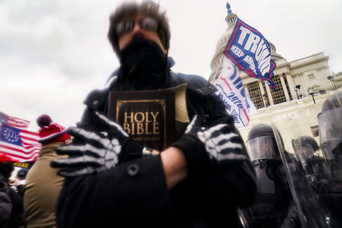 A man holds a Bible as Trump supporters gather outside the US Capitol on January 6, 2021.
