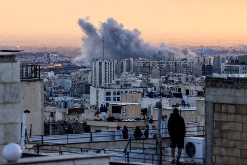 A person in Tehran looks at a plume of smoke after a strike on March 3.