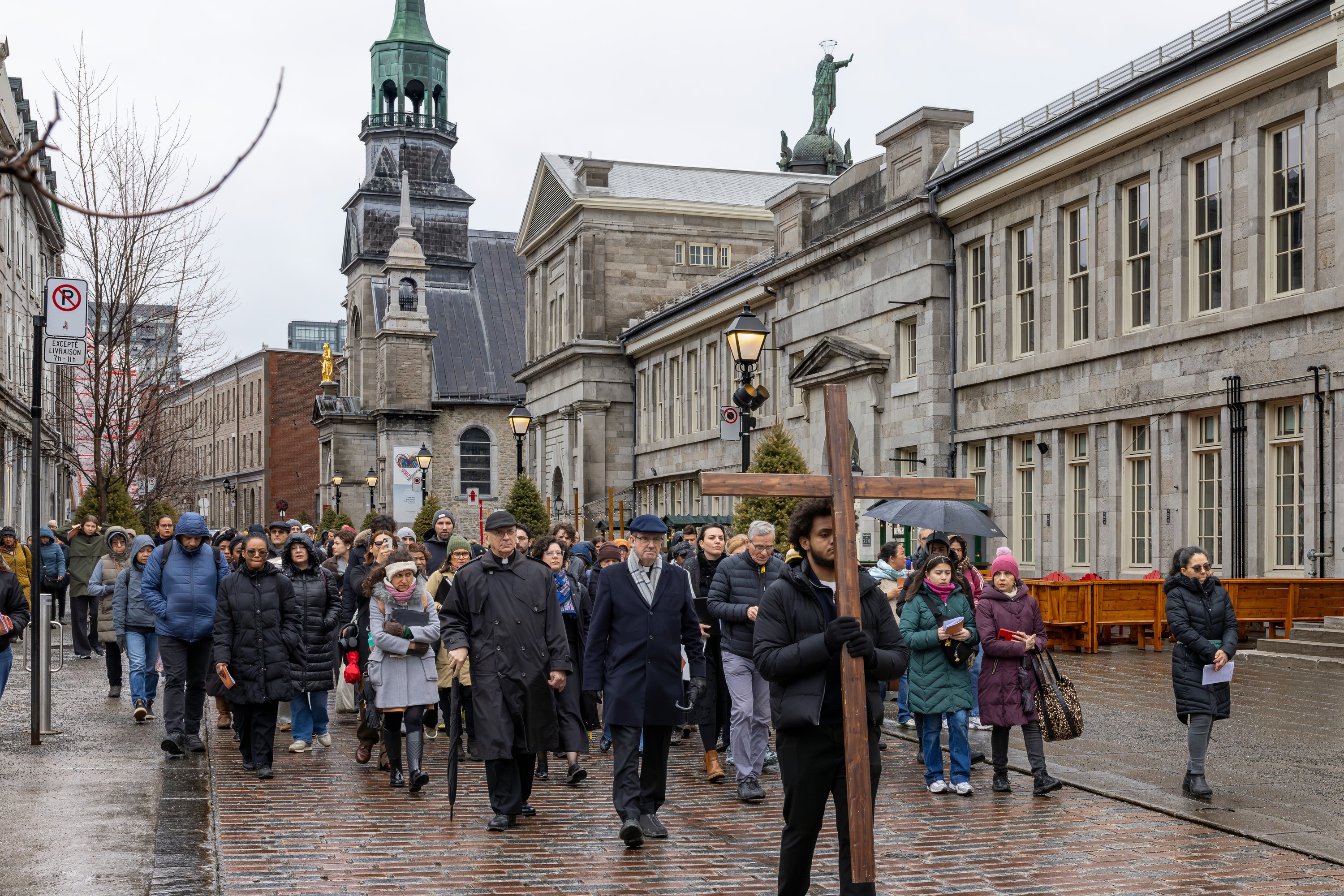 A man carries the cross on a street in Old Montreal on Good Friday.
