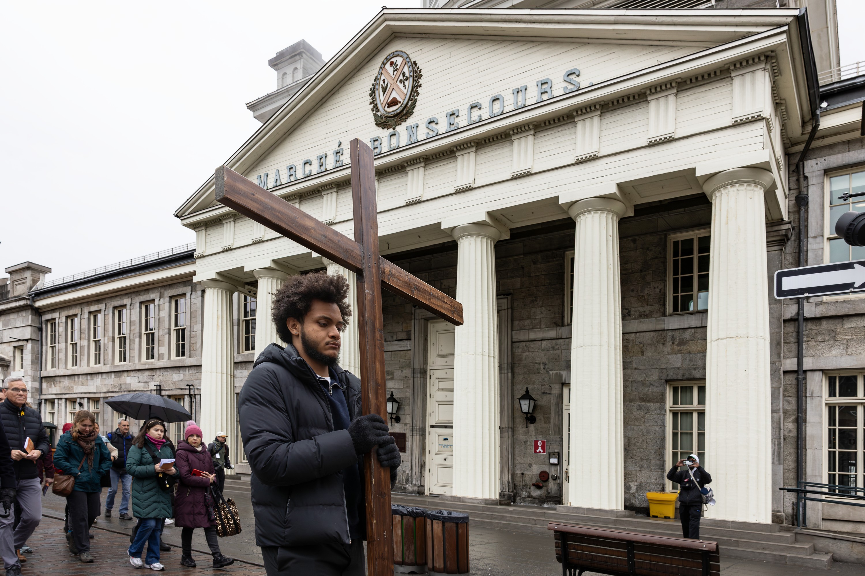 A man carrying the cross during the Way of the Cross march on Good Friday across from Marché Bonsecour in Old Montreal.