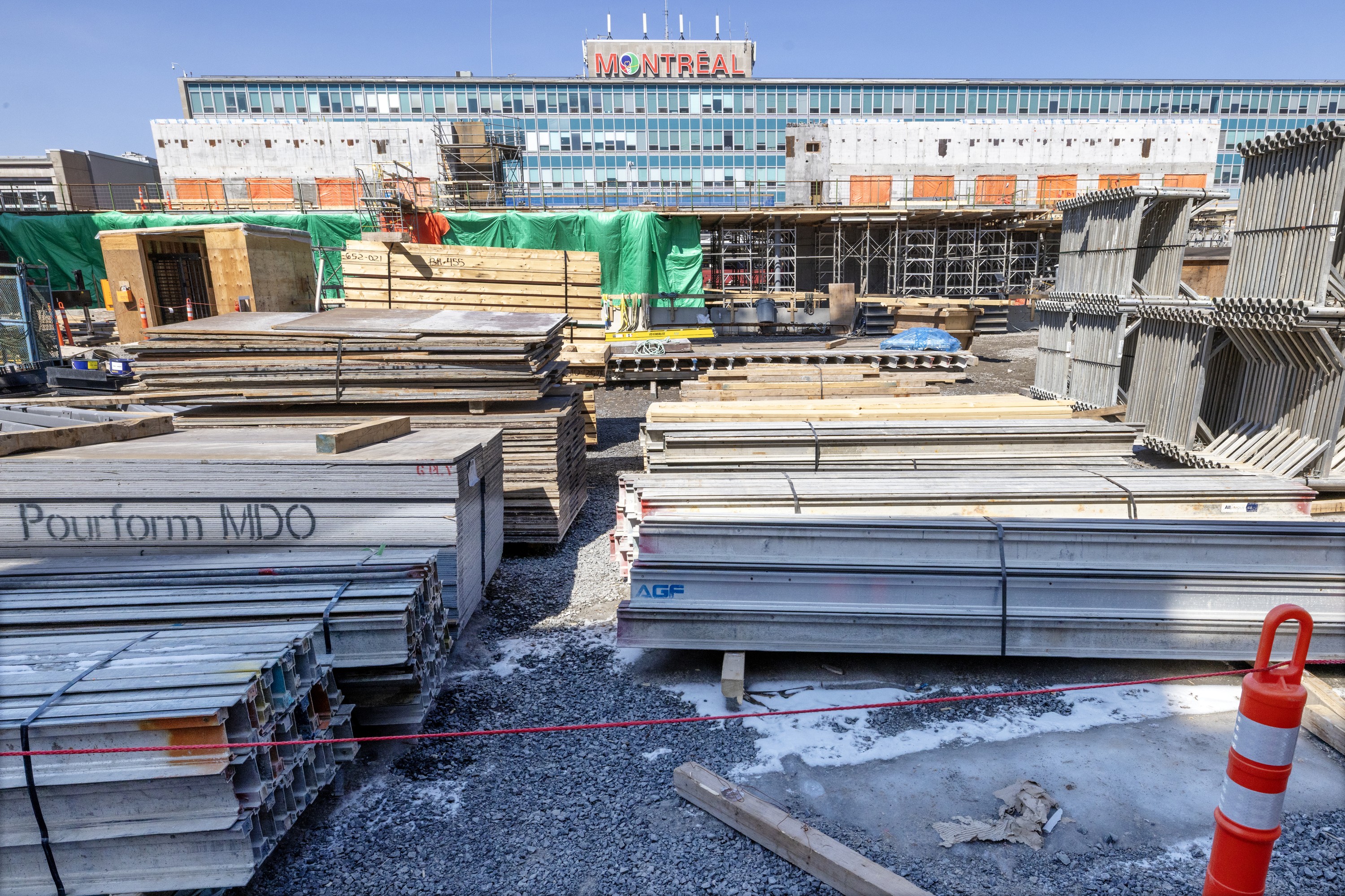 Construction material is spread out in front of Montreal's Trudeau airport, with the terminal in the background.