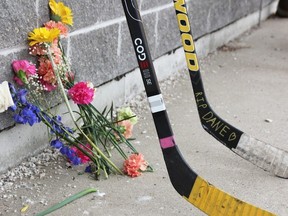 Flowers and hockey sticks were visible outside the patio entrance to the Lion's Den pub Sunday, in memory of Dane Nisbet.
