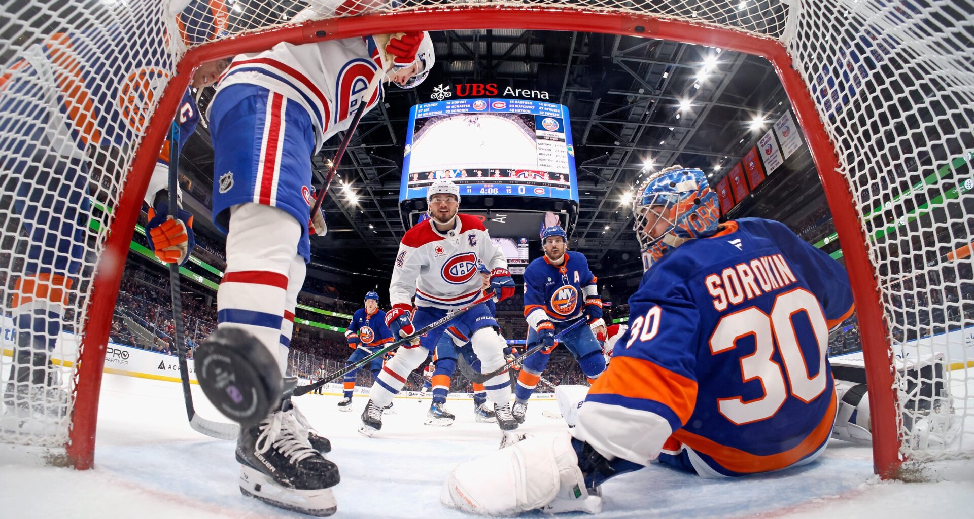 Canadiens captain Nick Suzuki, centre, scores a goal for his 100th point of the season during second period against Islanders