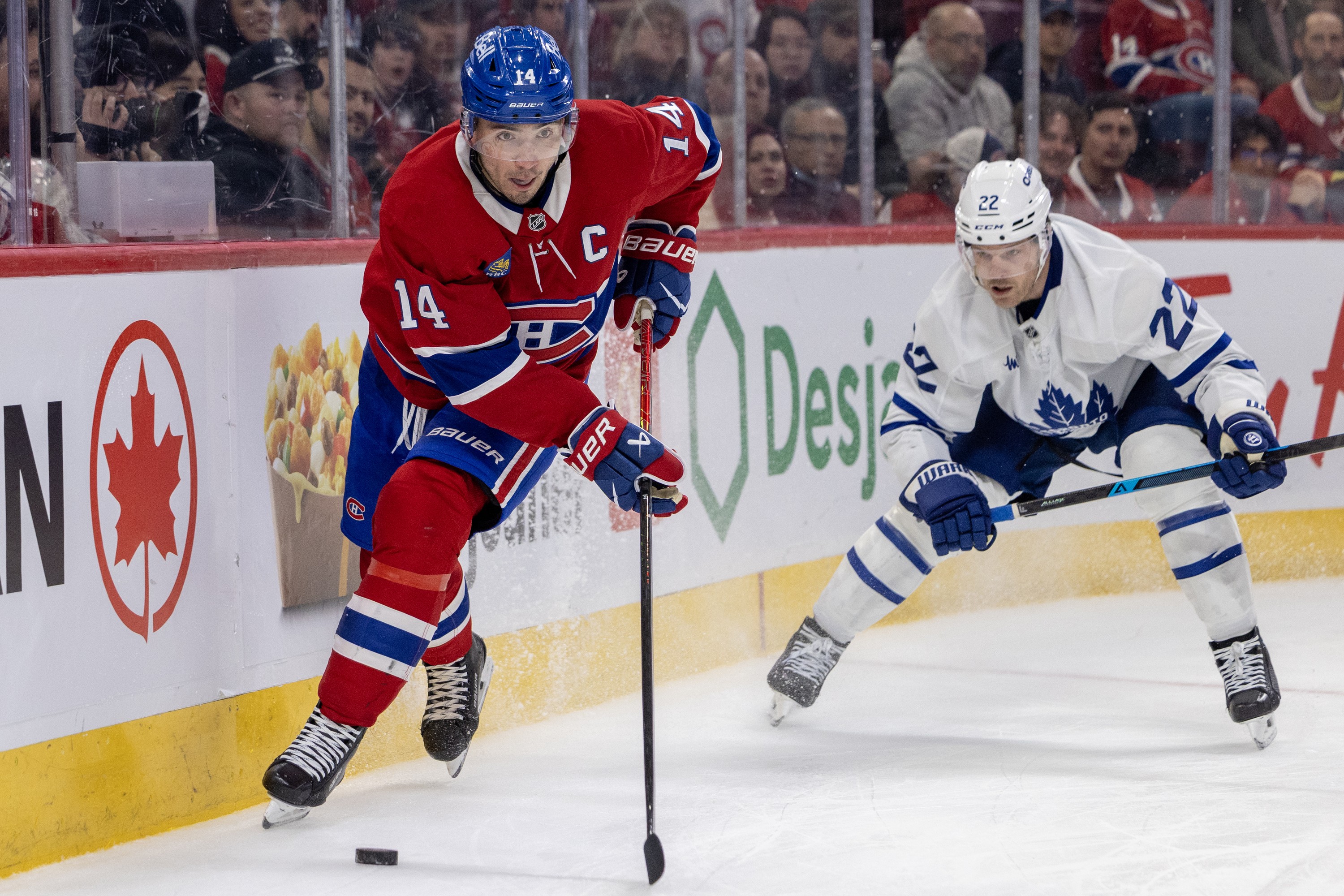 Maple Leafs' Jake McCabe pursues Canadiens captain Nick Suzuki behind the Toronto net during third period in Montreal on March 10.