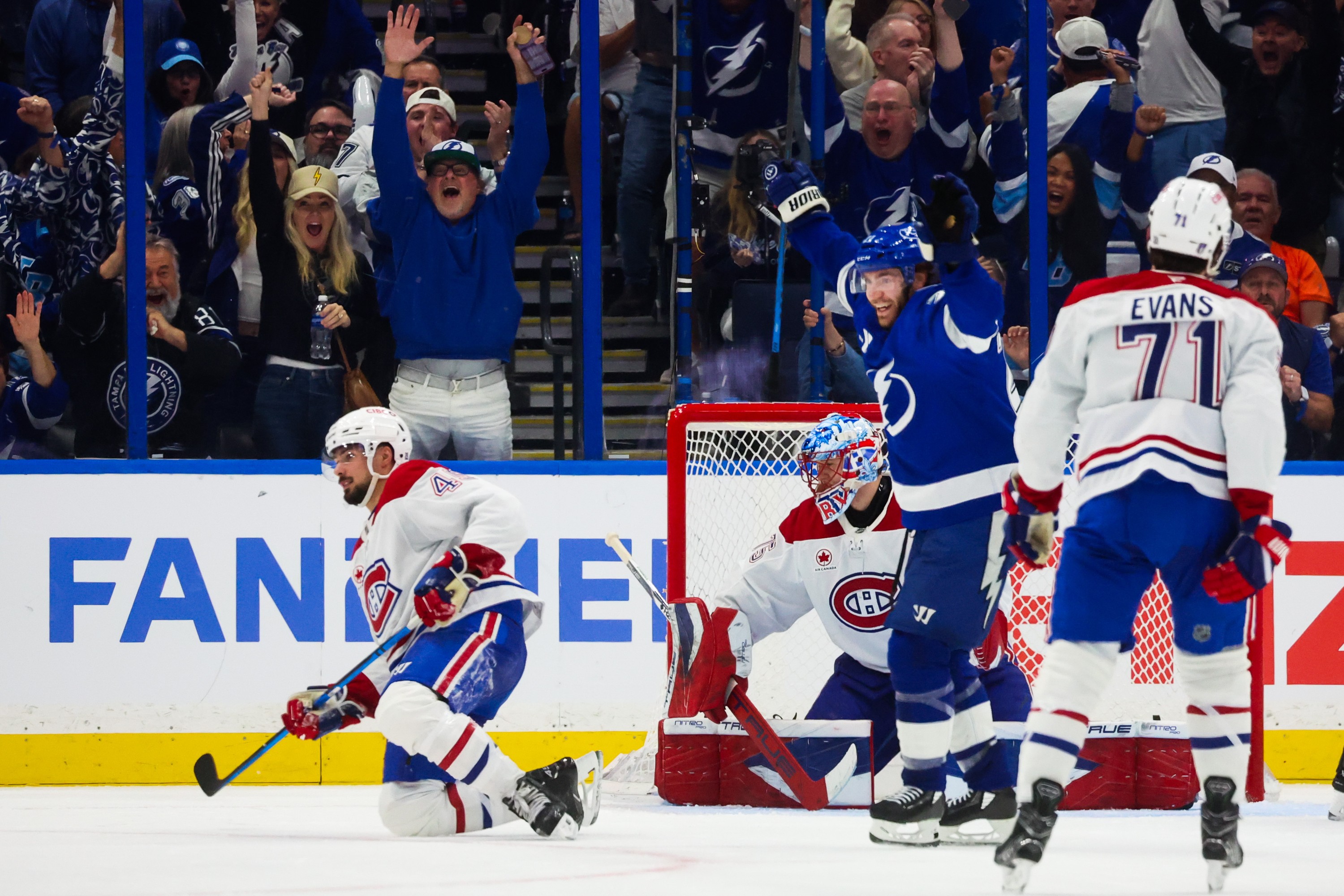 Tampa Bay Lightning centre Brayden Point celebrates a goal scored by a teammate as Montreal Canadiens defenceman Alexandre Carrier, goaltender Jakub Dobes and centre Jake Evans look on.