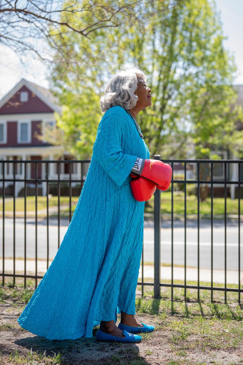 Lucas poses for a portrait wearing her boxing gloves, near her office.