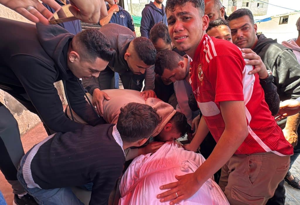 Palestinians bid farewell to the body of Majdi Mustafa Aslan, 54, at al-Aqsa Martyrs Hospital, who was killed by Israeli army fire while driving a World Health Organization medical evacuation convoy in Khan Younis, southern Gaza, April 6, 2026. (Photo: Ahmed Ibrahim/APA Images)