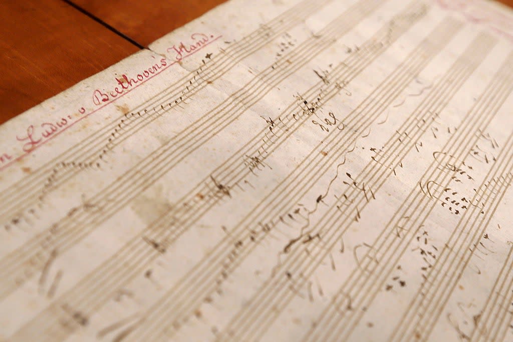 A close-up of a handwritten musical score by Beethoven, showcasing intricate notation and annotations on a sheet of music paper