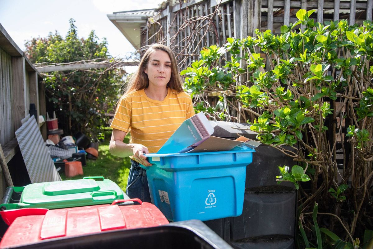 A young woman puts out the recycling