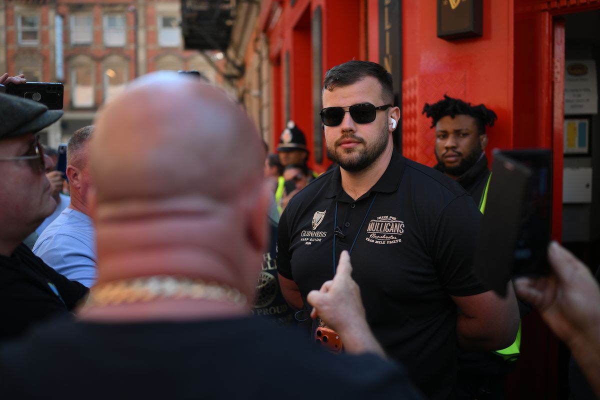 Protesters including Tommy Joyce appear to confront a member of staff at the pub