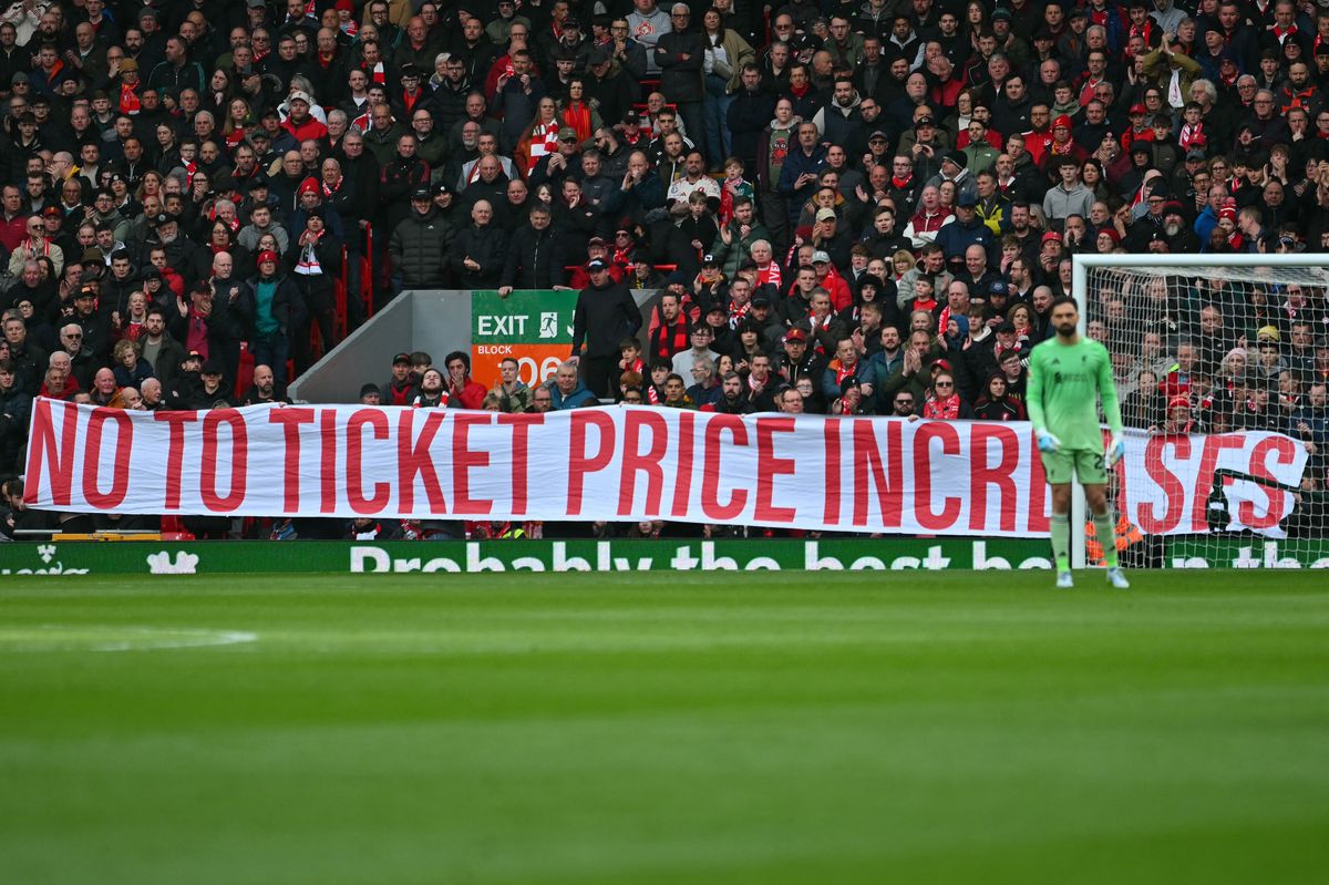Protesters display a banner against ticket price increases during the English Premier League football match between Liverpool and Fulham at Anfield in Liverpool, north west England on April 11, 2026. (Photo by ANDY BUCHANAN / AFP via Getty Images) / RESTRICTED TO EDITORIAL USE. No use with unauthorized audio, video, data, fixture lists, club/league logos or 'live' services. Online in-match use limited to 120 images. An additional 40 images may be used in extra time. No video emulation. Social media in-match use limited to 120 images. An additional 40 images may be used in extra time. No use in betting publications, games or single club/league/player publications. /