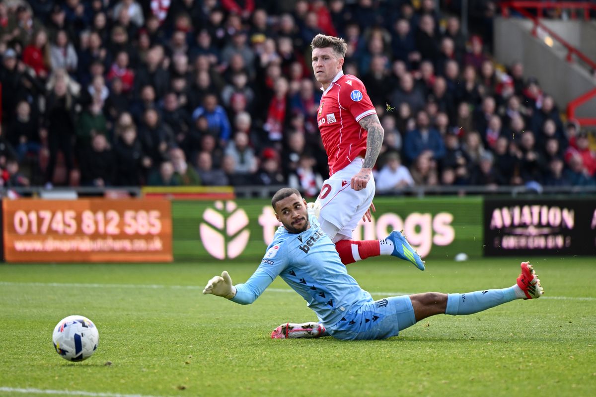 Josh Windass of Wrexham scores his team's second goal past Stoke goalkeeper Gavin Bazunu