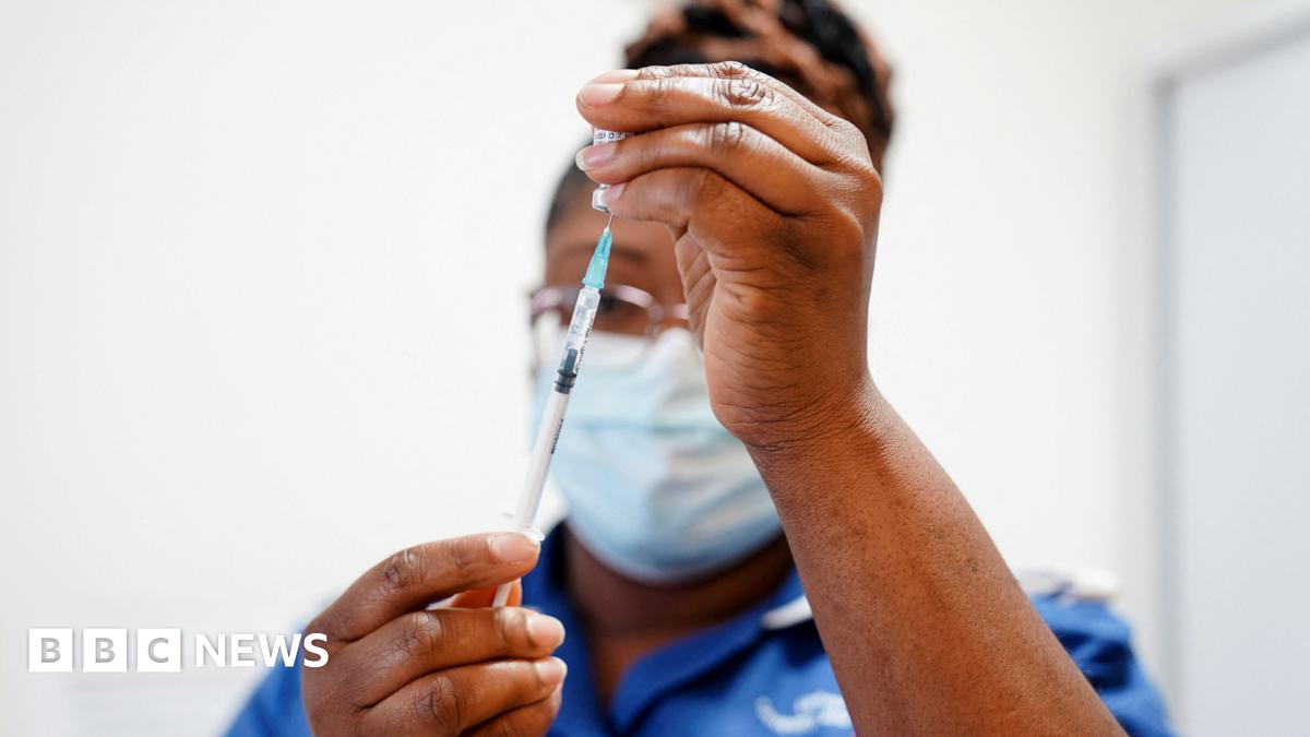 A nurse draws up a dose of vaccine into a syringe