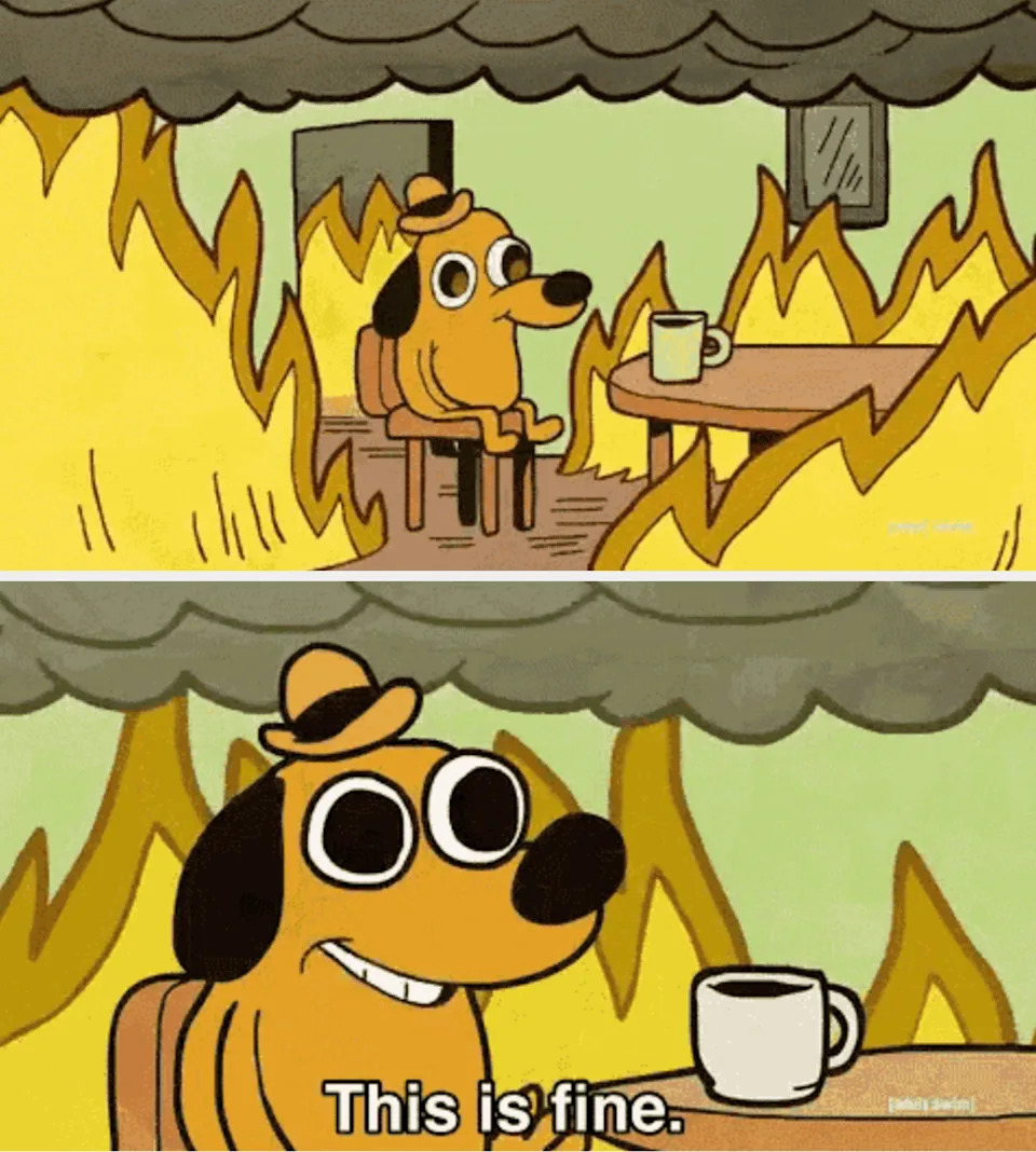 Cartoon dog sitting at a table with a mug, surrounded by flames, saying, "This is fine."