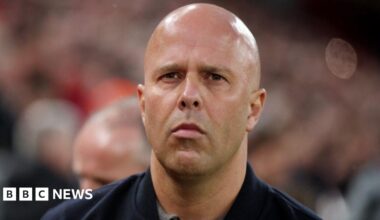 A close-up head shot of Arne Slot at Liverpool FC's Anfield stadium.