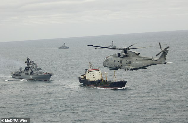 The Royal Navy will be forced to ask the French for help intercepting Russian vessels in British waters because the UK fleet is struggling to meet 'operational commitments', sources say. Pictured: HMS Somerset, HMS St Albans and a Merlin helicopter track a Russian vessel