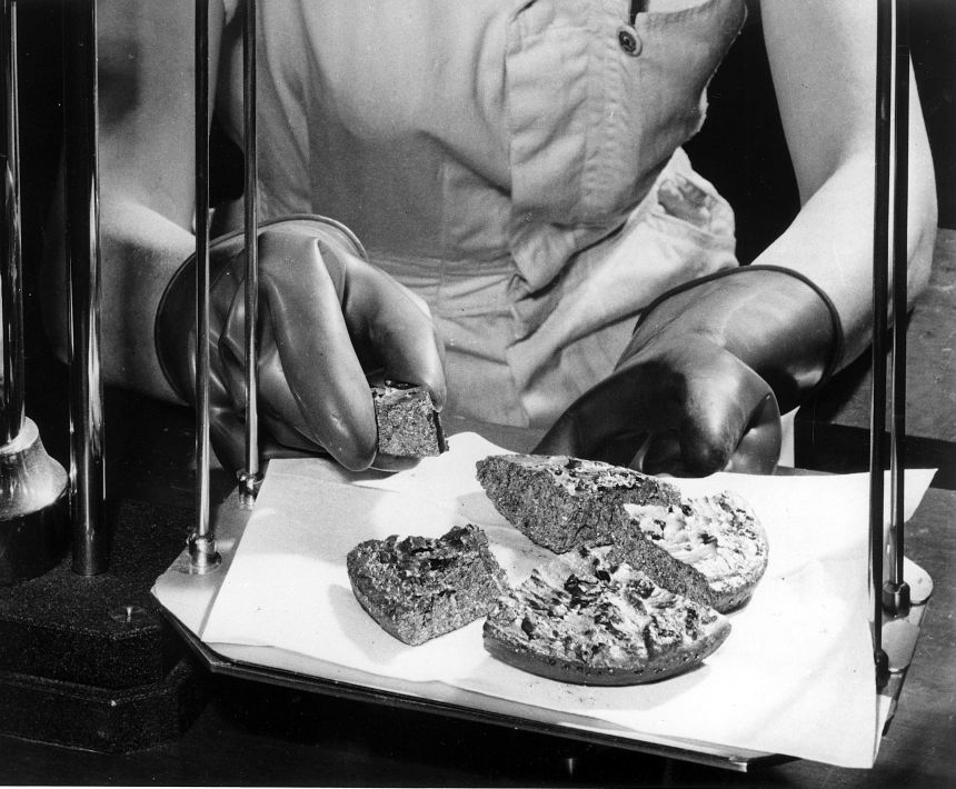A worker at the Atomic Energy Commission's Y-12 Plant at Oak Ridge, Tennessee, examines a biscuit of uranium metal, circa 1967.