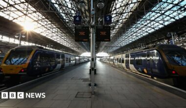 Two trains parked at a platform at Manchester Piccadilly station.