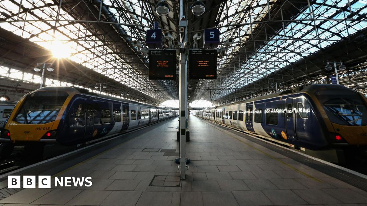 Two trains parked at a platform at Manchester Piccadilly station.